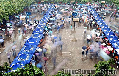 College graduates seek jobs in the rain at a job fair in Guangxi Zhuang Autonomous Region on April 27, 2008 