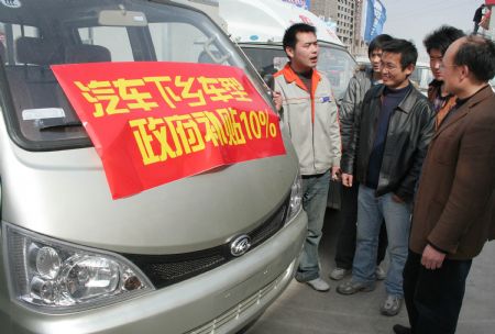 Local peasants prone to purchase of a minivan read the notice of 10 percent subsidies on designated types of automobile promoted to countryside, in Linyi City, east China's Shandong Province, March 15, 2009. China implements new sets of tax cuts and subsidies to boost demand for cars, with the intention on encouraging purchases of cars and other vehicles, especially in the vast countryside. They are meant to help autos and auto parts makers upgrade to more modern, energy-efficient technology. (Xinhua)