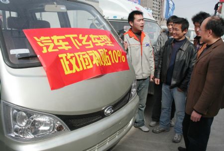 Local peasants prone to purchase of a minivan read the notice of 10 percent subsidies on designated types of automobile promoted to countryside, in Linyi City, east China's Shandong Province, March 15, 2009. China implements new sets of tax cuts and subsidies to boost demand for cars, with the intention on encouraging purchases of cars and other vehicles, especially in the vast countryside. They are meant to help autos and auto parts makers upgrade to more modern, energy-efficient technology. (Xinhua)