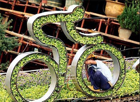 A worker fixes a 'green' cyclist at Tian'anmen Square to celebrate the Olympic Games. [China Daily]