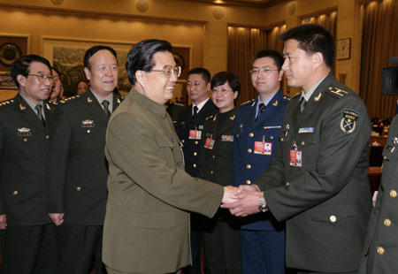 Chinese President Hu Jintao (front L), who is also chairman of the Central Military Commission, shakes hands with a deputy of the Chinese People&apos;s Liberation Army (PLA) to the Second Session of the 11th National People&apos;s Congress (NPC), in Beijing, capital of China, March 11, 2009. Hu Jintao attended the plenary meeting of the PLA delegation on Wednesday. (Xinhua/Wang Jianmin) 