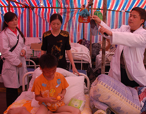 A doctor explains the nature of a boy’s wounds inside a makeshift hospital tent in Dujiangyan HUANG WEI/BEIJING REVIEW A doctor explains the nature of a boy’s wounds inside a makeshift hospital tent in Dujiangyan HUANG WEI/BEIJING REVIEW