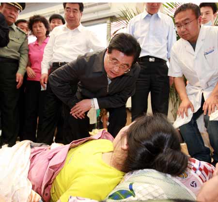 Chinese President Hu Jintao comforts a wounded woman in Mianyang, a city in quake-hit southwestern Sichuan Province, May 16, 2008.He encouraged them to be confident in overcoming hardships caused by the disaster. (Xinhua Photo)