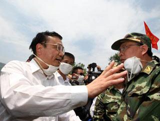 Chinese Vice Premier Li Keqiang (L), also member of the Standing Committee of the Political Bureau of the Communist Party of China (CPC) Central Committee, speaks to a rescuer during his visit to the quake-hit southwest China's Sichuan Province to direct quake relief on May 19, 2008. (Xinhua Photo)
