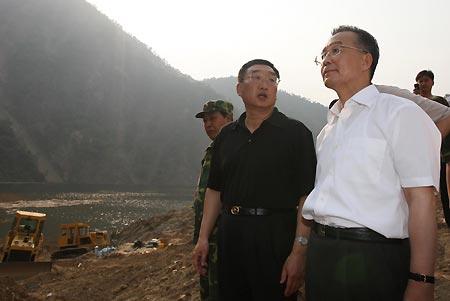 Chinese Premier Wen Jiabao (front R) listens as he inspects the drainage of the Tangjiashan quake lake in southwest China's Sichuan Province on June 5, 2008. (Xinhua/Liu Weibing