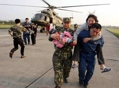 Rescuers transport injured from the quake-stricken Yingxiu Town of Wenchuan County to Chengdu, capital of southwest China&apos;s Sichuan Province, May 14, 2008. Helicopters took relief teams from various circles to Wenchuan and then transport the injured to Chengdu on the way back. (Xinhua Photo)