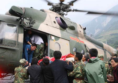 The wounded is lifted to a helicopter in Yingxiu Town of Wenchuan County, the epicenter of Monday's massive earthquake on May 14, 2008. (Xinhua Photo)