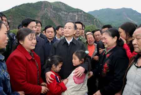 Chinese Premier Wen Jiabao (C) consoles locals as he pays a visit to Beichuan County, which neighbors the epicenter of the massive quake in southwest China's Sichuan Province, May 14, 2008. Wen Jiabao arrived on Wednesday at Beichuan County, one of the regions worst hit by Monday's massive earthquake, to oversee the rescue work. (Xinhua Photo)
