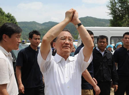 Chinese Premier Wen Jiabao greets local people during an inspection in Muyu Township of Qingchuan County, one of the worst-hit area of Guangyuan City in southwest China's Sichuan Province, May 15, 2008. Wen is here to oversee rescue work and visit survivors. [Xinhua]
